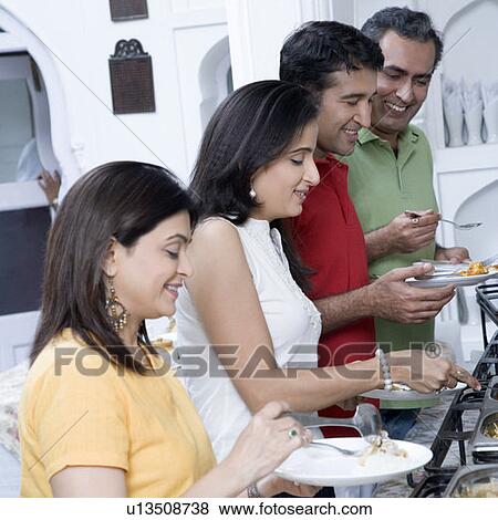 Side profile of two mid adult couples having food in a party View Large Photo Image Stock Photo - Side profile of two mid adult couples having food in a party. Fotosearch