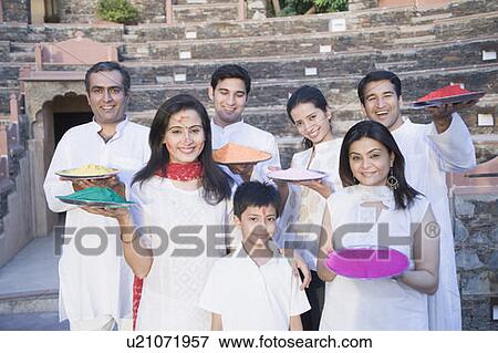 Stock Photo - Two mid adult couples and a young couple with a boy holding plates of powder paint. Fotosearch