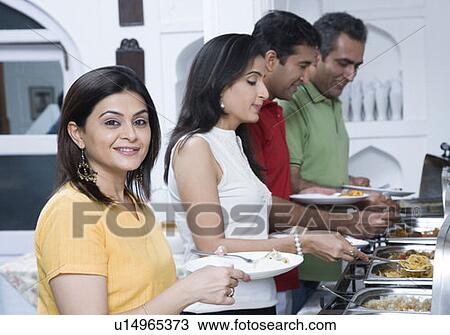Stock Image - Two mid adult couples having lunch. Fotosearch