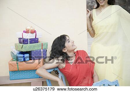 Two young women smiling together View Large Photo Image Stock Photo - Two young women smiling together. Fotosearch