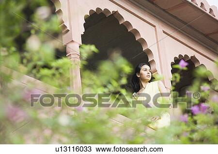 Young woman sitting on the balustrade of a palace, Neemrana Fort Palace, Neemrana, Alwar, Rajasthan, India View Large Photo Image Stock Image - Young woman sitting on the balustrade of a palace, Neemrana Fort Palace, Neemrana, Alwar, Rajasthan, India. Fotosearch