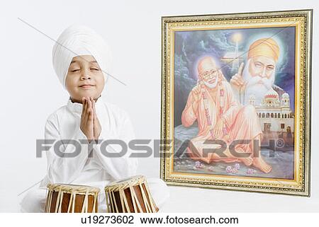 Boy sitting in front of bongo and praying View Large Photo Image Stock Image - Boy sitting in front of bongo and praying . Fotosearch