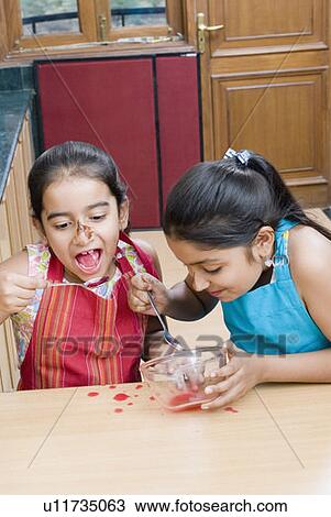 Close-up of a girl eating jam with her sister View Large Photo Image Stock Image - Close-up of a girl eating jam with her sister. Fotosearch