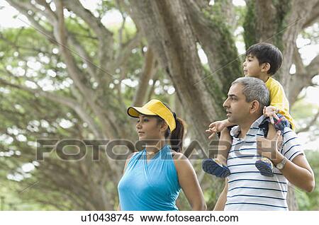 Mid adult man carrying his son on his shoulder with his wife standing beside him View Large Photo Image Stock Photography - Mid adult man carrying his son on his shoulder with his wife standing beside him. Fotosearch