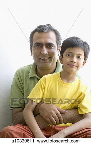 Portrait of a boy sitting with his father View Large Photo Image Stock Image - Portrait of a boy sitting with his father. Fotosearch