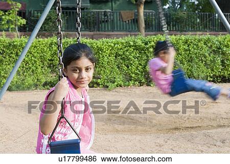 Portrait of a girl sitting on a swing View Large Photo Image Stock Photograph - Portrait of a girl sitting on a swing. Fotosearch