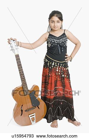 Stock Image - Portrait of a girl standing and holding a guitar. Fotosearch