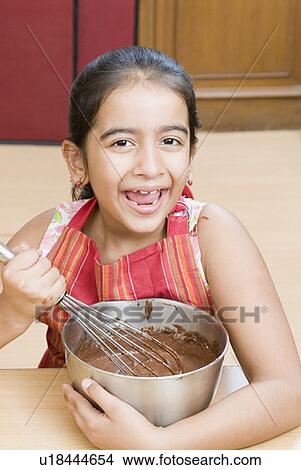 Portrait of a girl stirring chocolate sauce with an egg beater View Large Photo Image Picture - Portrait of a girl stirring chocolate sauce with an egg beater. Fotosearch