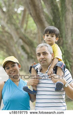 Portrait of a mid adult man carrying his son on his shoulder with his wife standing beside him View Large Photo Image Stock Photography - Portrait of a mid adult man carrying his son on his shoulder with his wife standing beside him. Fotosearch