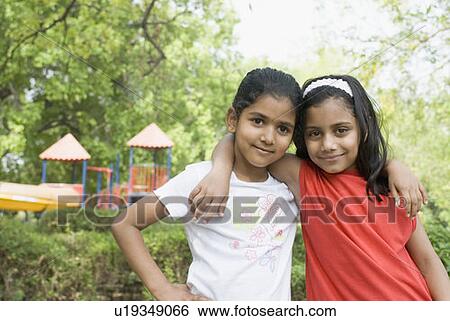 Portrait of two girls with their arms around each other View Large Photo Image Stock Photograph - Portrait of two girls with their arms around each other. Fotosearch