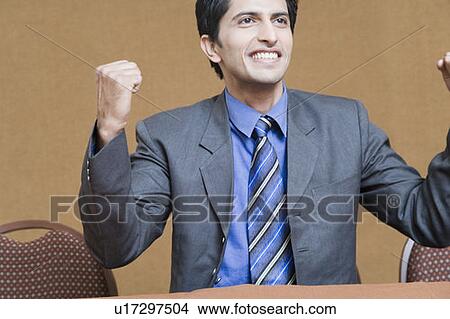 Picture - Close-up of a businessman making his fists and smiling. Fotosearch