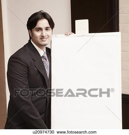 Stock Image - Portrait of a businessman giving presentation near a whiteboard. Fotosearch