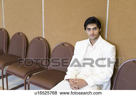 Stock Photo - Portrait of a businessman sitting on a chair. Fotosearch