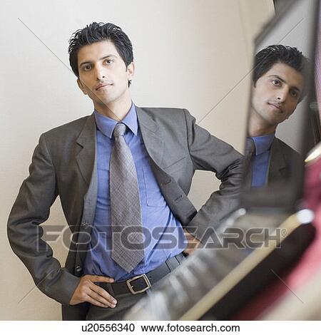 Stock Image - Portrait of a businessman standing with a laptop in front of him on a lectern. Fotosearch