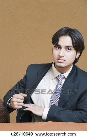 Portrait of a businessman with his finger in his coat's pocket View Large Photo Image Stock Photo - Portrait of a businessman with his finger in his coat's pocket. Fotosearch