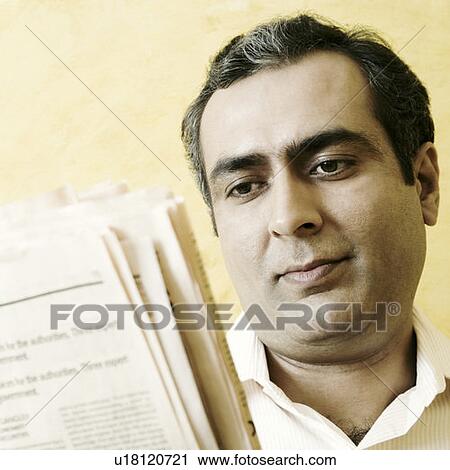Close-up of a mid adult man reading a newspaper View Large Photo Image Stock Image - Close-up of a mid adult man reading a newspaper. Fotosearch