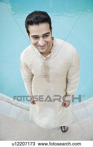 High angle view of a young man standing at the poolside View Large Photo Image Stock Image - High angle view of a young man standing at the poolside. Fotosearch