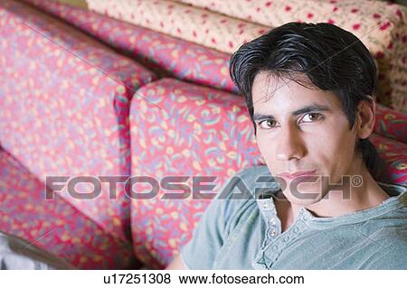 Portrait of a young man sitting on a couch View Large Photo Image Stock Photo - Portrait of a young man sitting on a couch. Fotosearch