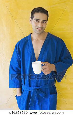 Stock Image - Portrait of a young woman holding a cup of coffee. Fotosearch