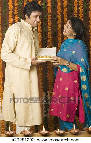 Side profile of a mid adult man and a young woman holding a box of sweets View Large Photo Image Stock Image - Side profile of a mid adult man and a young woman holding a box of sweets. Fotosearch