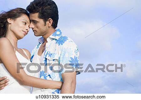 Side profile of a young couple romancing View Large Photo Image Stock Photography - Side profile of a young couple romancing. Fotosearch