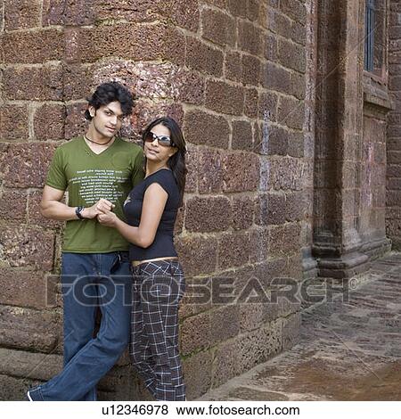 Young couple leaning against a wall, Goa, India View Large Photo Image Stock Photo - Young couple leaning against a wall, Goa, India. Fotosearch