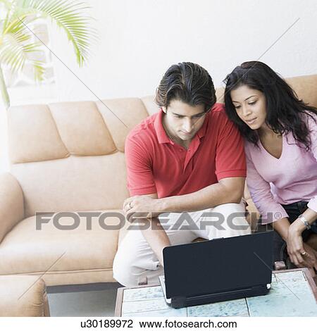 Young couple using a laptop View Large Photo Image Stock Image - Young couple using a laptop. Fotosearch