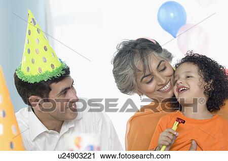 Stock Image - Boy smiling with his grandmother and his father. Fotosearch