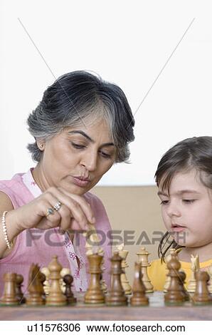 Close-up of a mature woman playing chess with her granddaughter View Large Photo Image Stock Photograph - Close-up of a mature woman playing chess with her granddaughter. Fotosearch