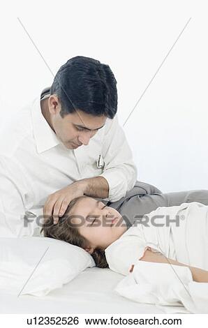 Close-up of a mid adult man sitting beside his daughter sleeping on the bed View Large Photo Image Stock Photograph - Close-up of a mid adult man sitting beside his daughter sleeping on the bed. Fotosearch