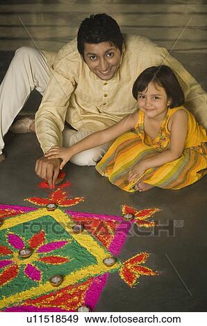 High angle view of a mid adult man making rangoli with his daughter View Large Photo Image Stock Photo - High angle view of a mid adult man making rangoli with his daughter. Fotosearch