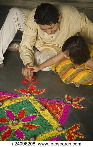 High angle view of a mid adult man making rangoli with his daughter View Large Photo Image Stock Photo - High angle view of a mid adult man making rangoli with his daughter. Fotosearch