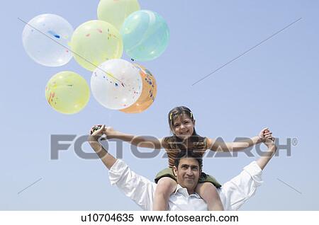 Low angle view of a mid adult man carrying his daughter on his shoulders and smiling View Large Photo Image Stock Photography - Low angle view of a mid adult man carrying his daughter on his shoulders and smiling. Fotosearch