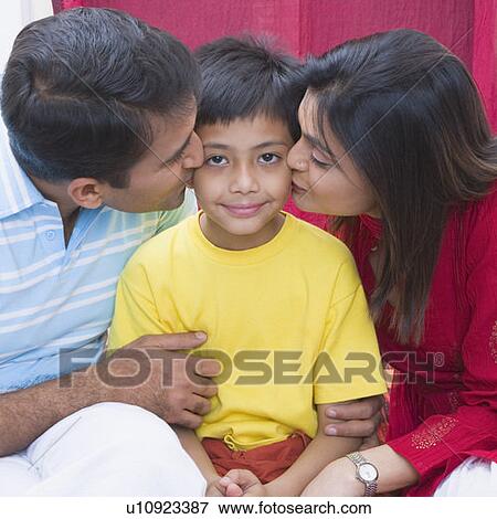 Mid adult couple kissing their son View Large Photo Image Stock Photo - Mid adult couple kissing their son. Fotosearch