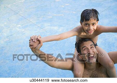 Mid adult man carrying his son on his shoulders in a swimming pool View Large Photo Image Stock Photo - Mid adult man carrying his son on his shoulders in a swimming pool. Fotosearch