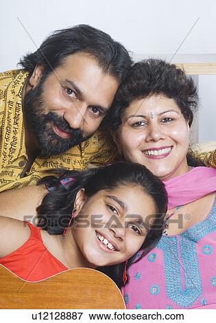 Portrait of a mid adult couple smiling with their daughter View Large Photo Image Stock Photo - Portrait of a mid adult couple smiling with their daughter. Fotosearch