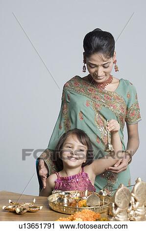 Young woman with her daughter preparing for pooja View Large Photo Image Stock Image - Young woman with her daughter preparing for pooja. Fotosearch