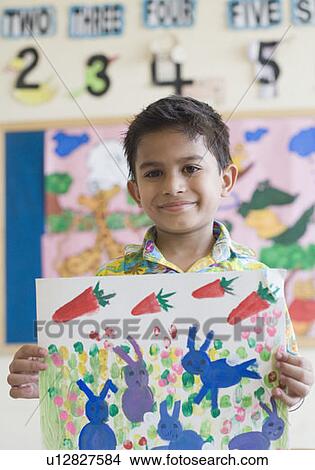 Close-up of a schoolboy showing a painting View Large Photo Image Picture - Close-up of a schoolboy showing a painting. Fotosearch