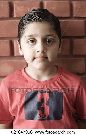 Portrait of a boy standing in front of a wall View Large Photo Image Stock Photograph - Portrait of a boy standing in front of a wall. Fotosearch