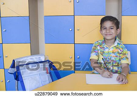 Stock Photo - Portrait of a schoolboy drawing on a sheet of paper. Fotosearch