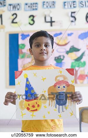 Portrait of a schoolboy showing a painting View Large Photo Image Stock Photo - Portrait of a schoolboy showing a painting. Fotosearch