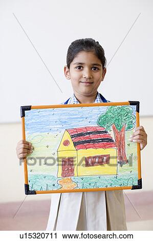 Stock Image - Portrait of a schoolgirl showing a picture frame and smirking. Fotosearch