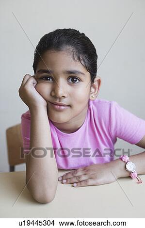 Portrait of a schoolgirl sitting at a table View Large Photo Image Picture - Portrait of a schoolgirl sitting at a table. Fotosearch
