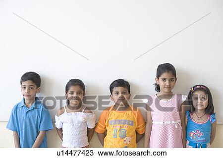 Stock Image - Portrait of three schoolgirls and two schoolboys standing in a row. Fotosearch