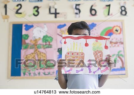 Stock Image - Schoolboy showing a painting. Fotosearch