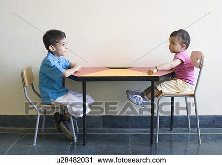 Side profile of two boys sitting at a table View Large Photo Image Stock Image - Side profile of two boys sitting at a table. Fotosearch