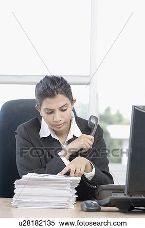 Stock Photography - Close-up of a businesswoman holding a telephone receiver. Fotosearch