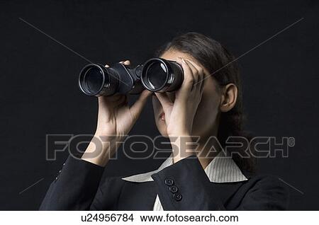 Picture - Close-up of a businesswoman looking through binoculars. Fotosearch