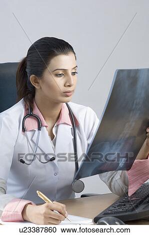 Stock Image - Close-up of a female doctor examining an X-Ray. Fotosearch