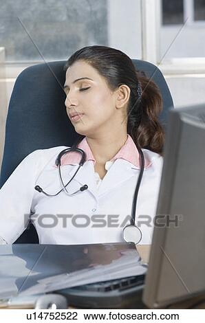 Stock Image - Close-up of a female doctor sleeping. Fotosearch